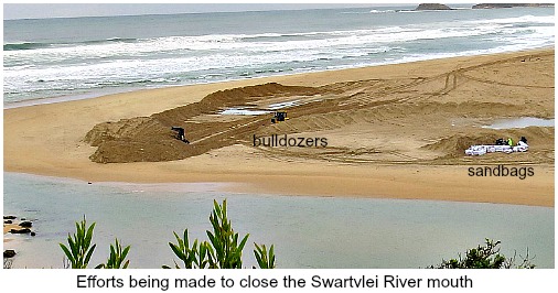 Buldozers and sandbags at the river-mouth