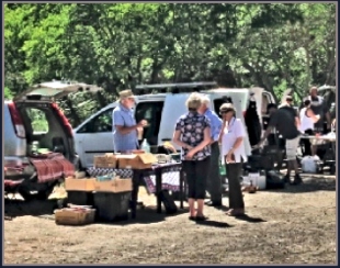 People gathering around at a Sunday morning car boot sale int Whistlestop Cafe parking ground.