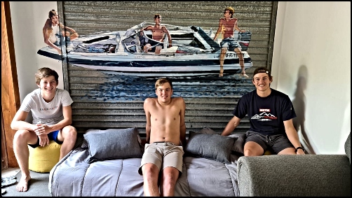 The painted garage wall mural of 3 young guys on their boat. The painted garage wall mural of 3 young guys on their boat.