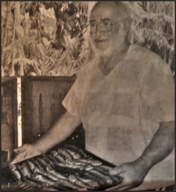 Gerry carrying his smoked sardines special into his shop