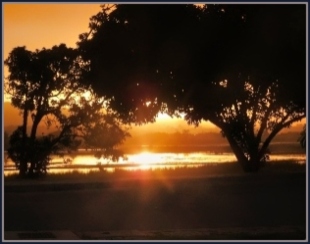 A liquid gold sunset spills on to the lagoon in front of our house