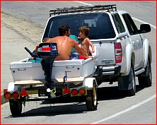 People in a boat trailer  towed by a vehicle