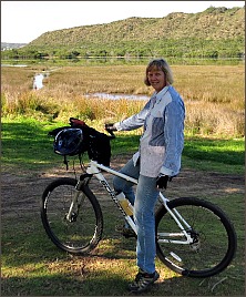 Sylvia on her bicycle next to the Swartvlei Lagoon.